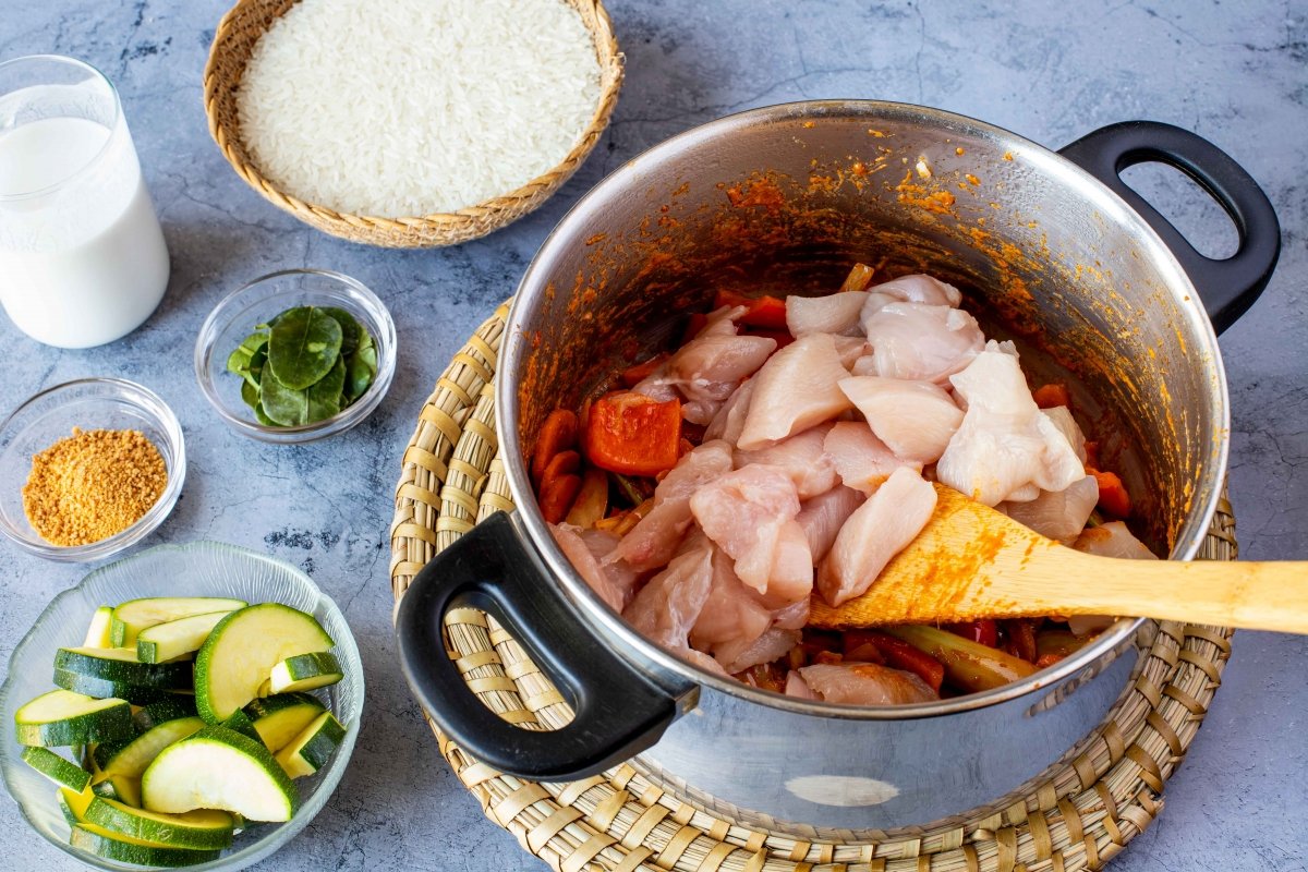Rehogar pollo con las verduras para hacer el curry rojo de verduras y pollo