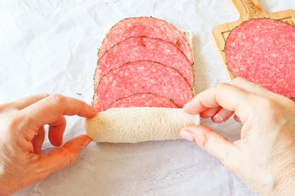 Rellenar con salami y enrollar el rollo de pan de molde