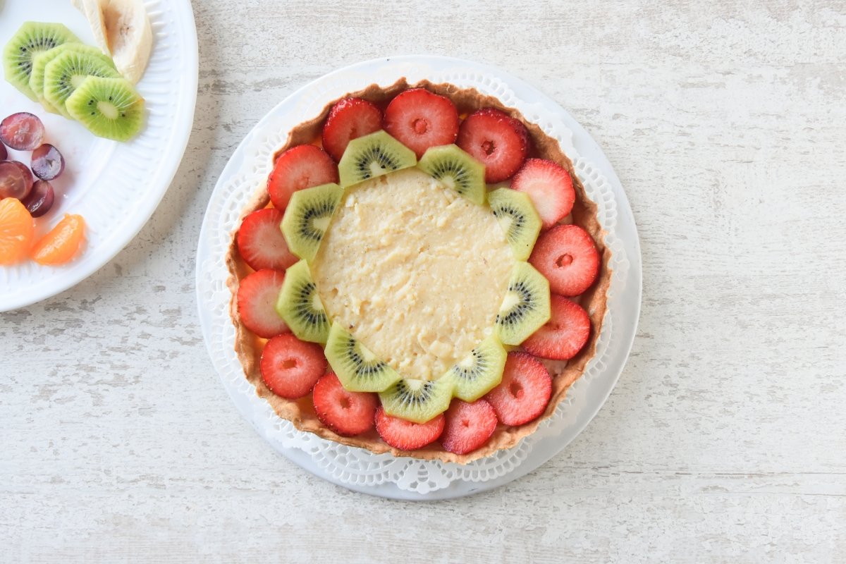 Rellenar la base de la tarta de frutas con crema pastelera