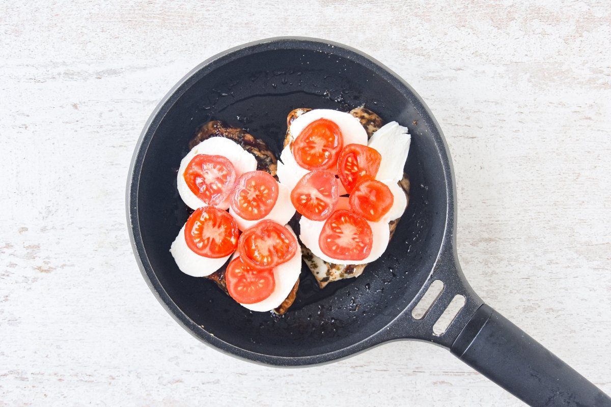 Repartimos el queso y los tomates encima del pollo