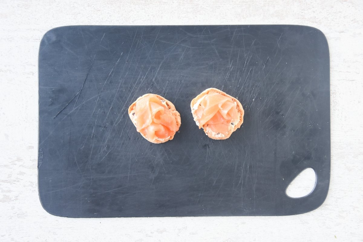 Repartimos la mantequilla y cubrimos con salmón