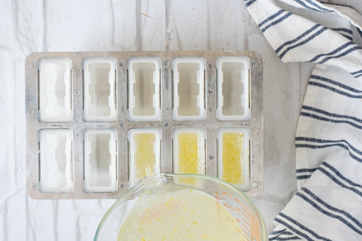 We distribute the mixture of the homemade lemon popsicles