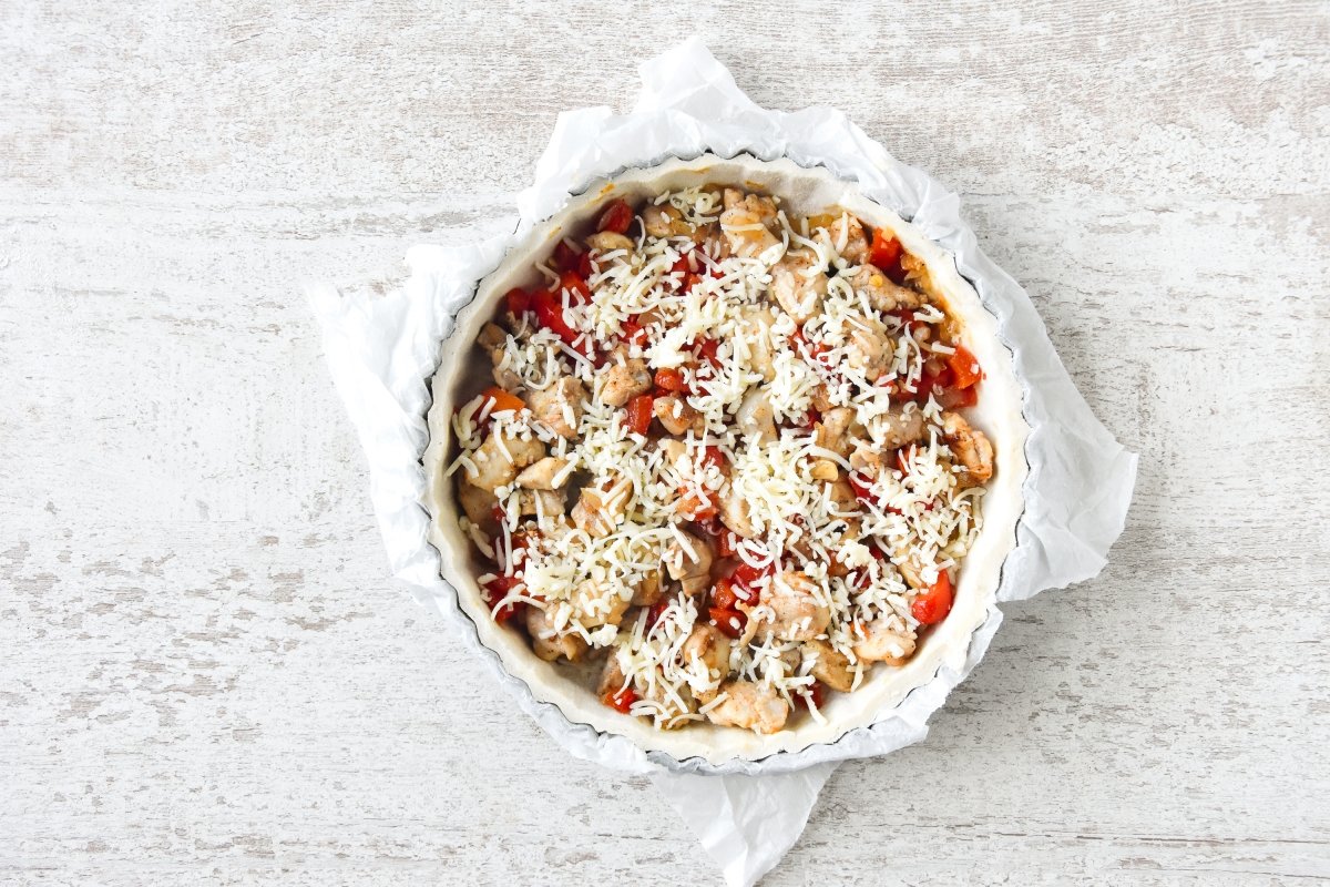 Repartimos la mezcla de pollo sobre la masa