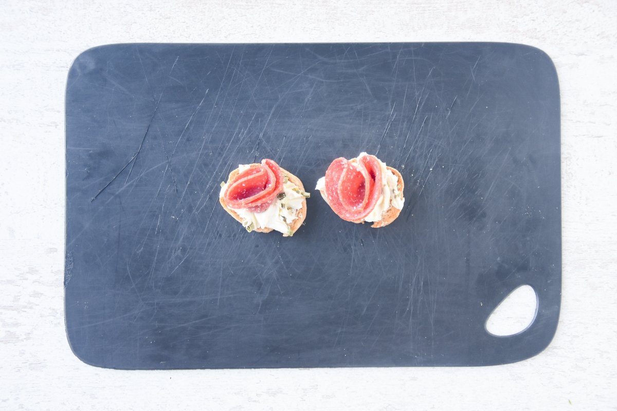 Repartimos la mezcla de queso y formamos una flor con el salami