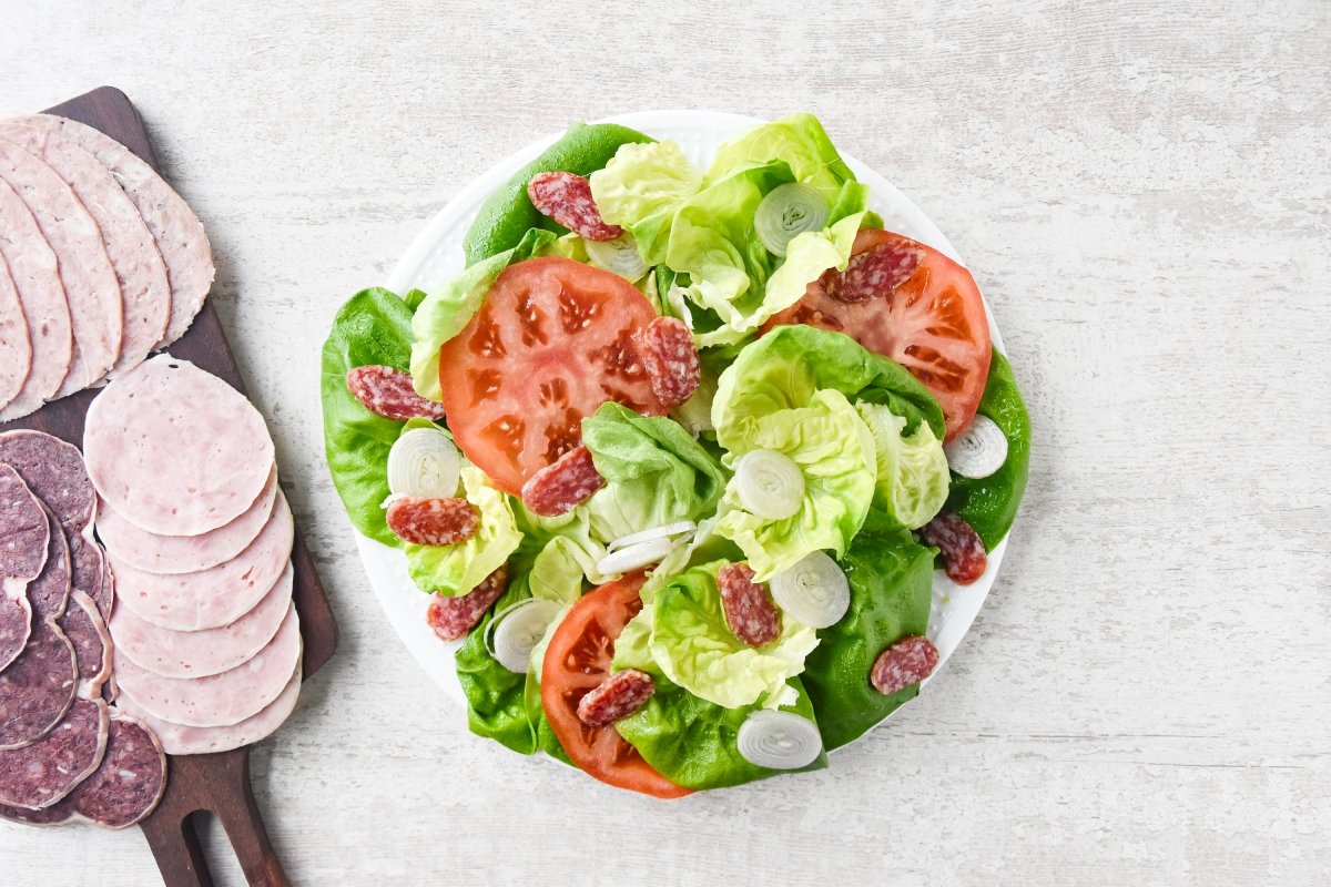Repartimos los embutidos sobre la ensalada