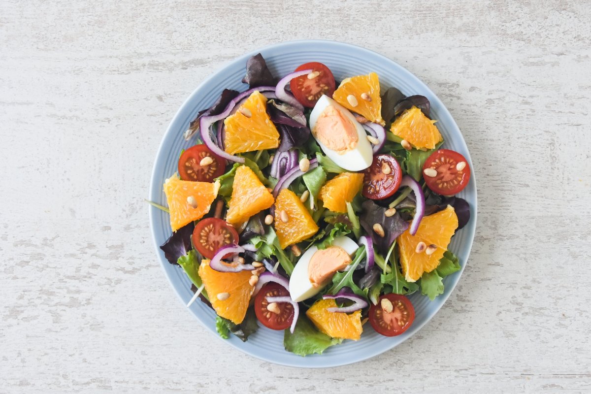 Repartimos los ingredientes de la ensalada de naranja en un plato