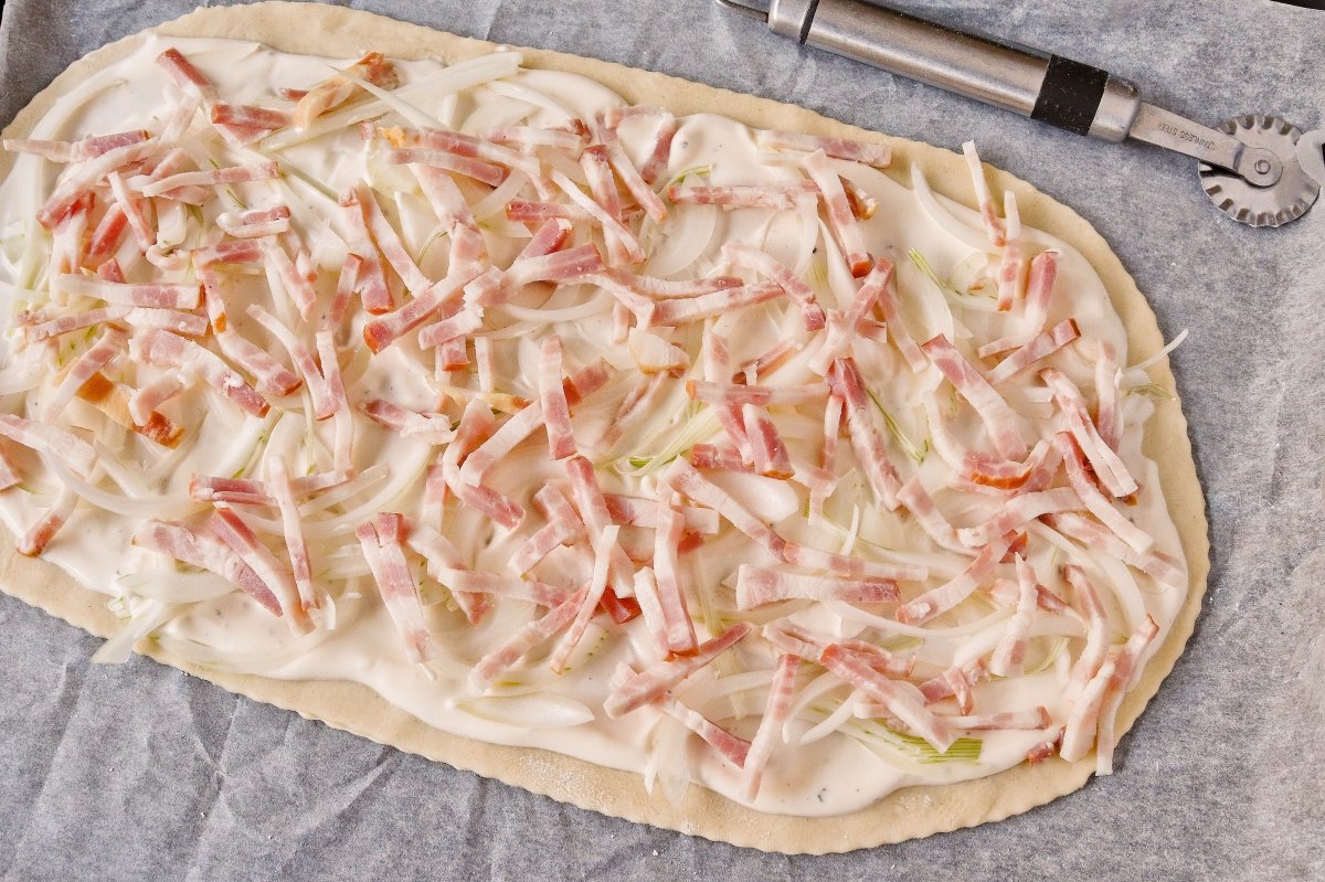 Repartir la cebolla y la panceta sobre el flammkuchen