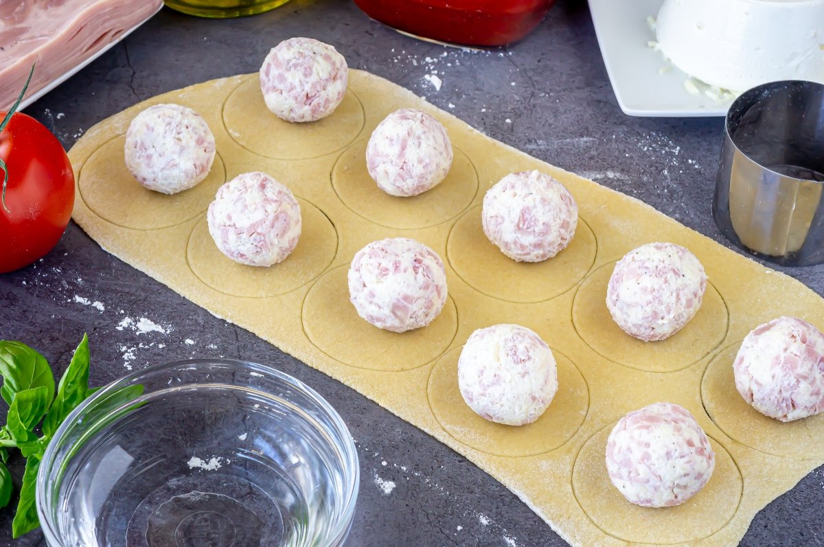 Repartir las bolas de relleno sobre la masa