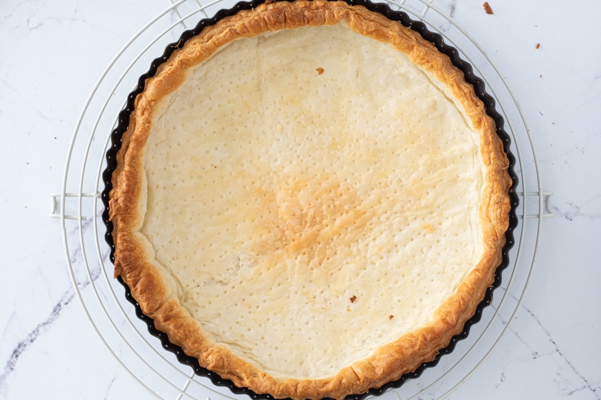 Retiramos del horno la masa de la tarta de manzana con crema pastelera