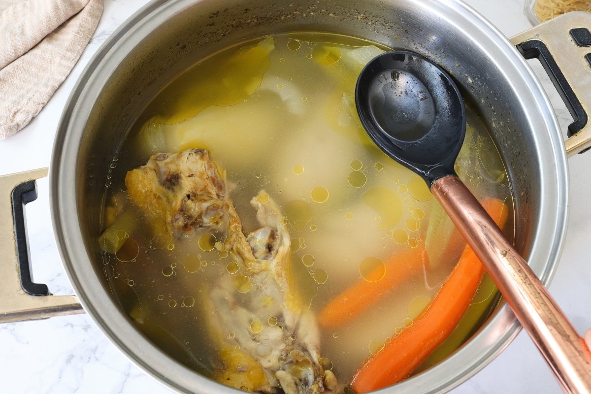 Retirar las impurezas a la sopa de pollo
