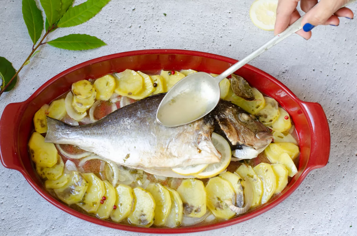 Rociando la dorada a la sidra con la salsa