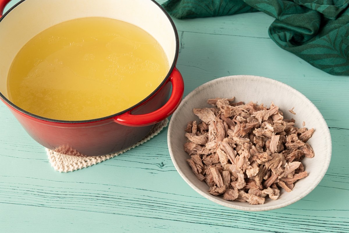 Sacar carnes del caldo y cortarlas para añadir después al pozole rojo
