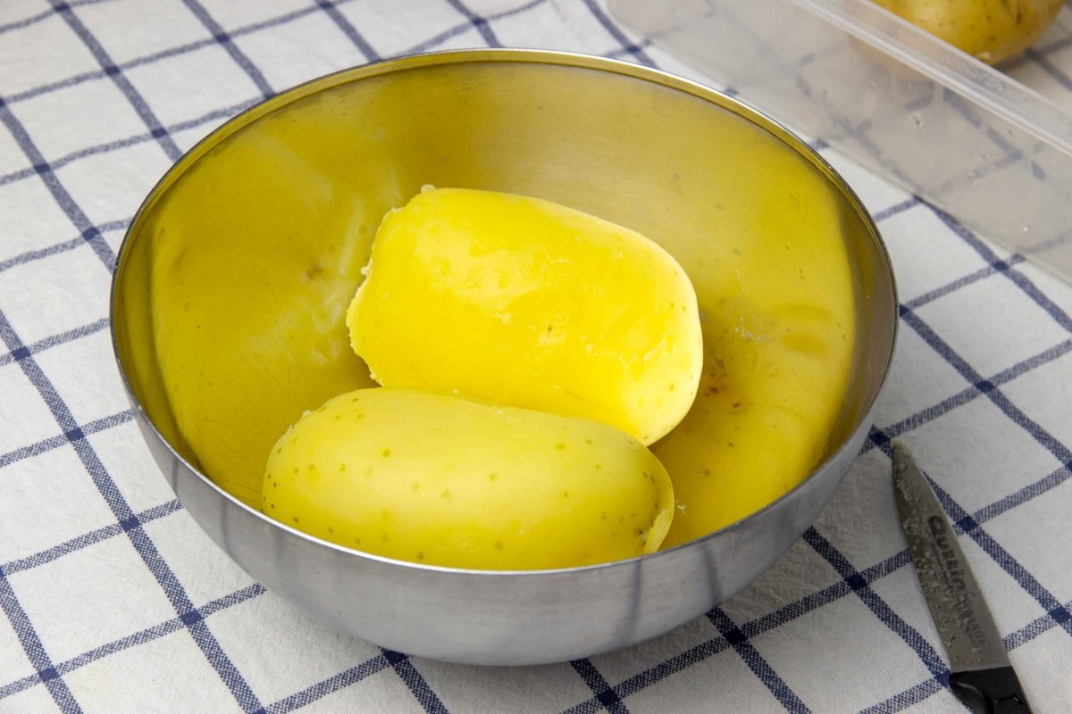 Sacar las patatas y pelarlas para hacer la masa de croquetas de patata
