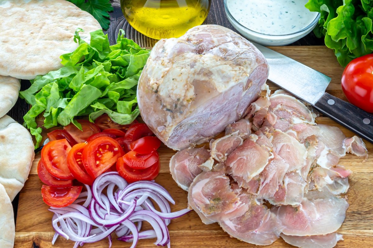 Sacar lonchas del kebab y cortar las guarniciones