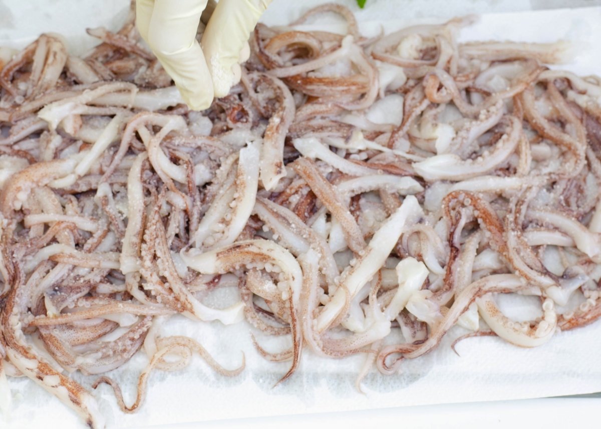 Salando los tentáculos para hacer rejos fritos
