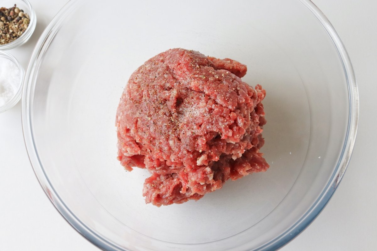 Salpimentar la carne picada para las albóndigas de carne en salsa verde
