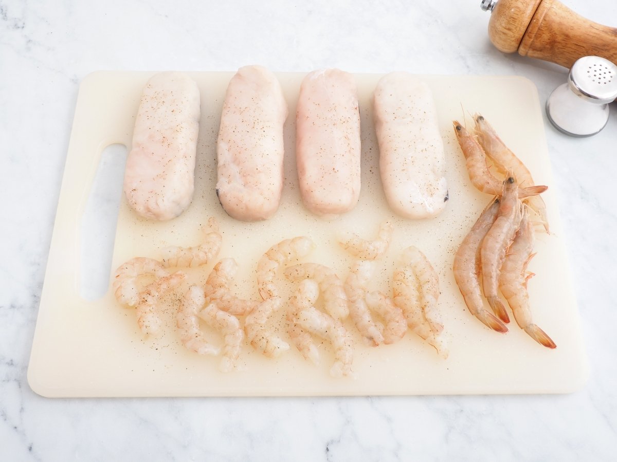 Salpimentar la merluza y las gambas