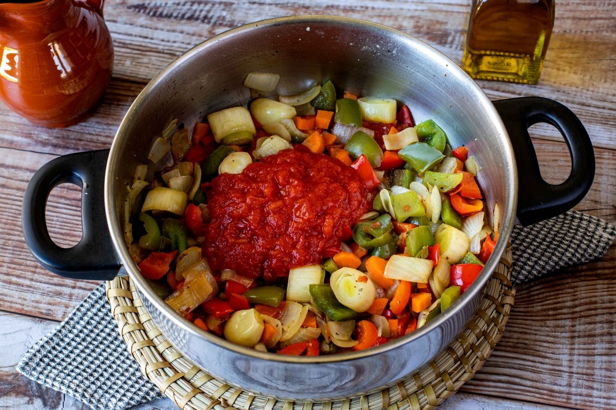 Salpimentar verduras y añadir salsa de tomate para la carne de ternera en salsa