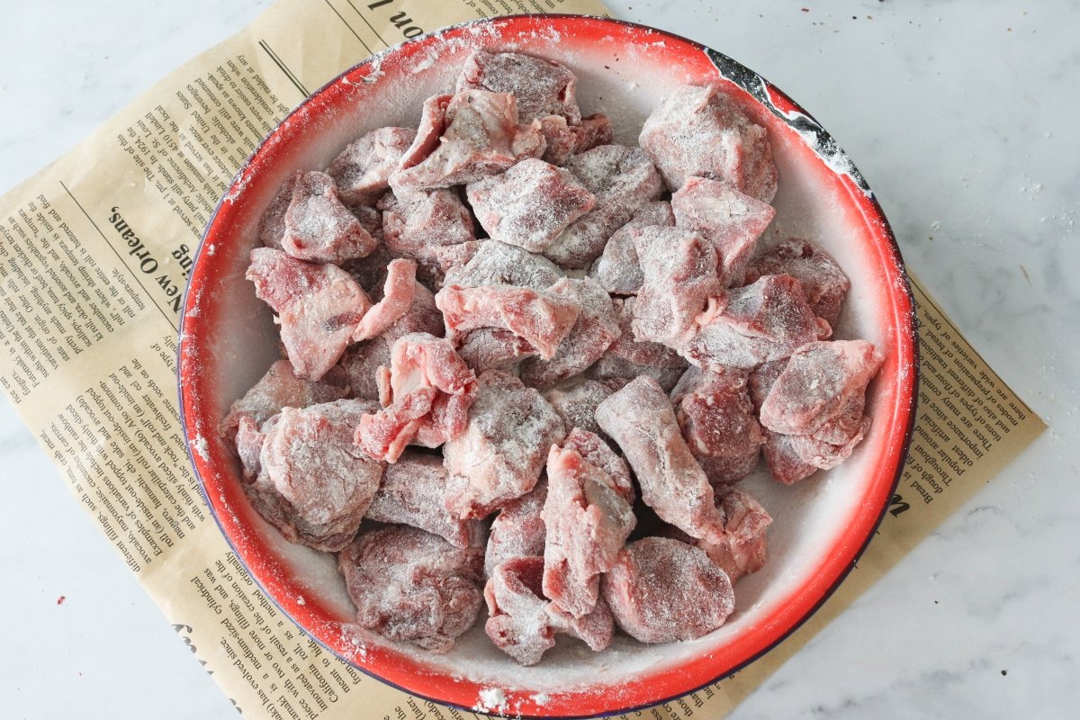 Salpimentar y enharinar la carne para el goulash húngaro