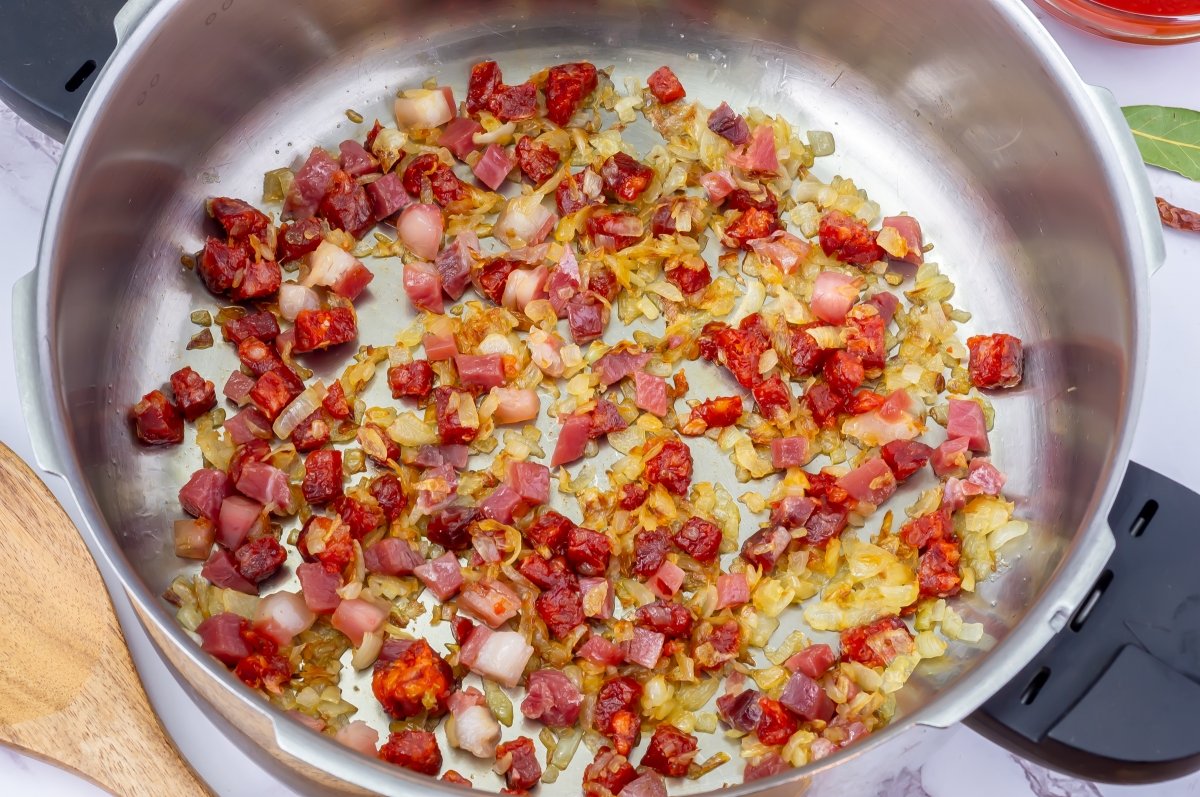 Salpimentar y especiar el sofrito de los caracoles en salsa
