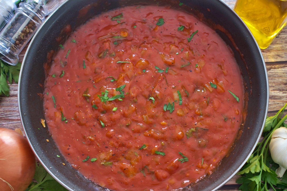 Salsa de tomate en la sartén para la corvina en salsa de tomate