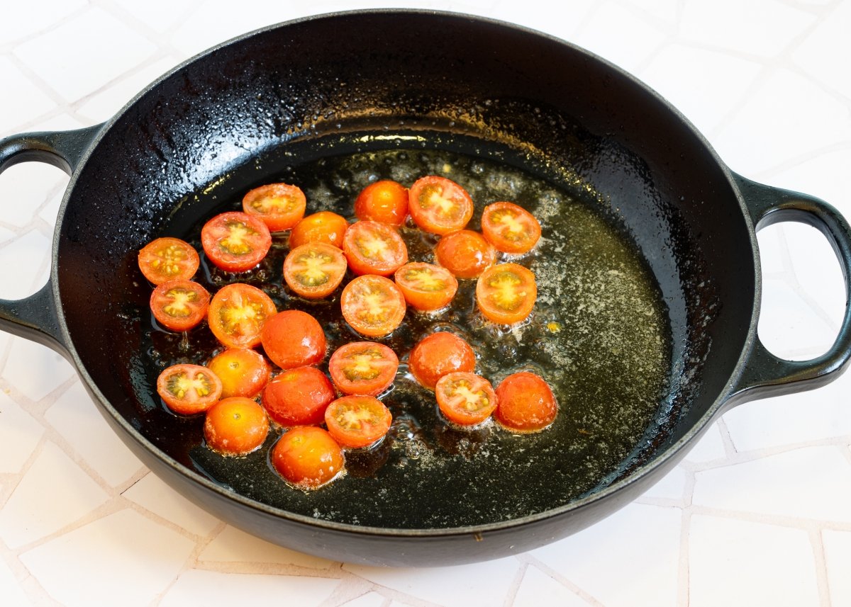 Salteando cherris para hacer espaguetis con espinacas