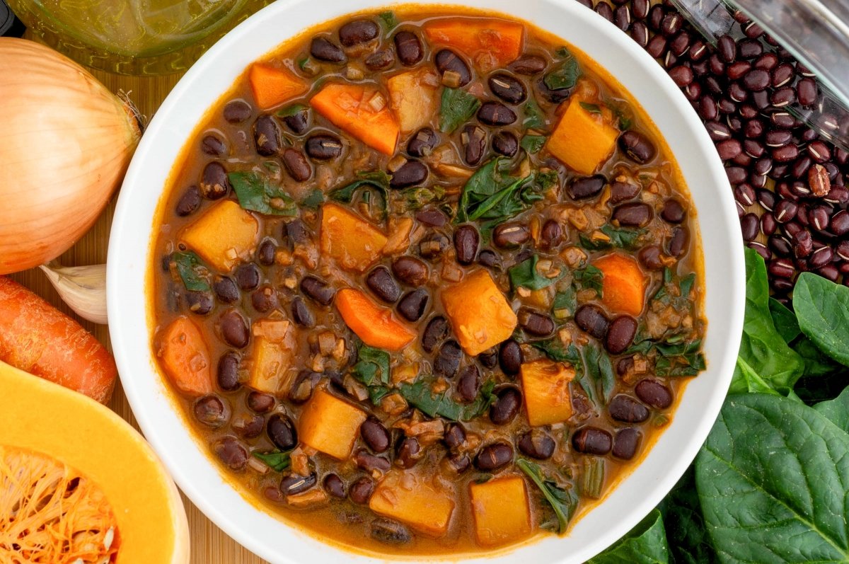 Servir o reposar las azukis estofadas con calabaza y verduras
