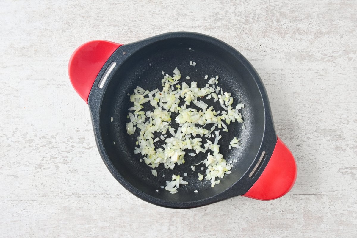 Sofreímos la cebolla para preparar el arroz con sepia