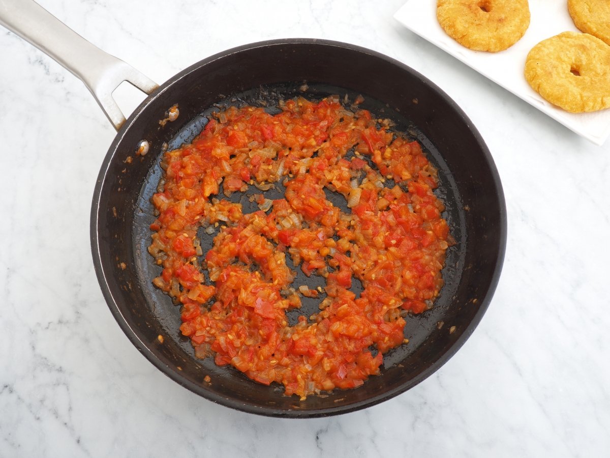 Sofreír cebolla con tomate para los huevos pericos
