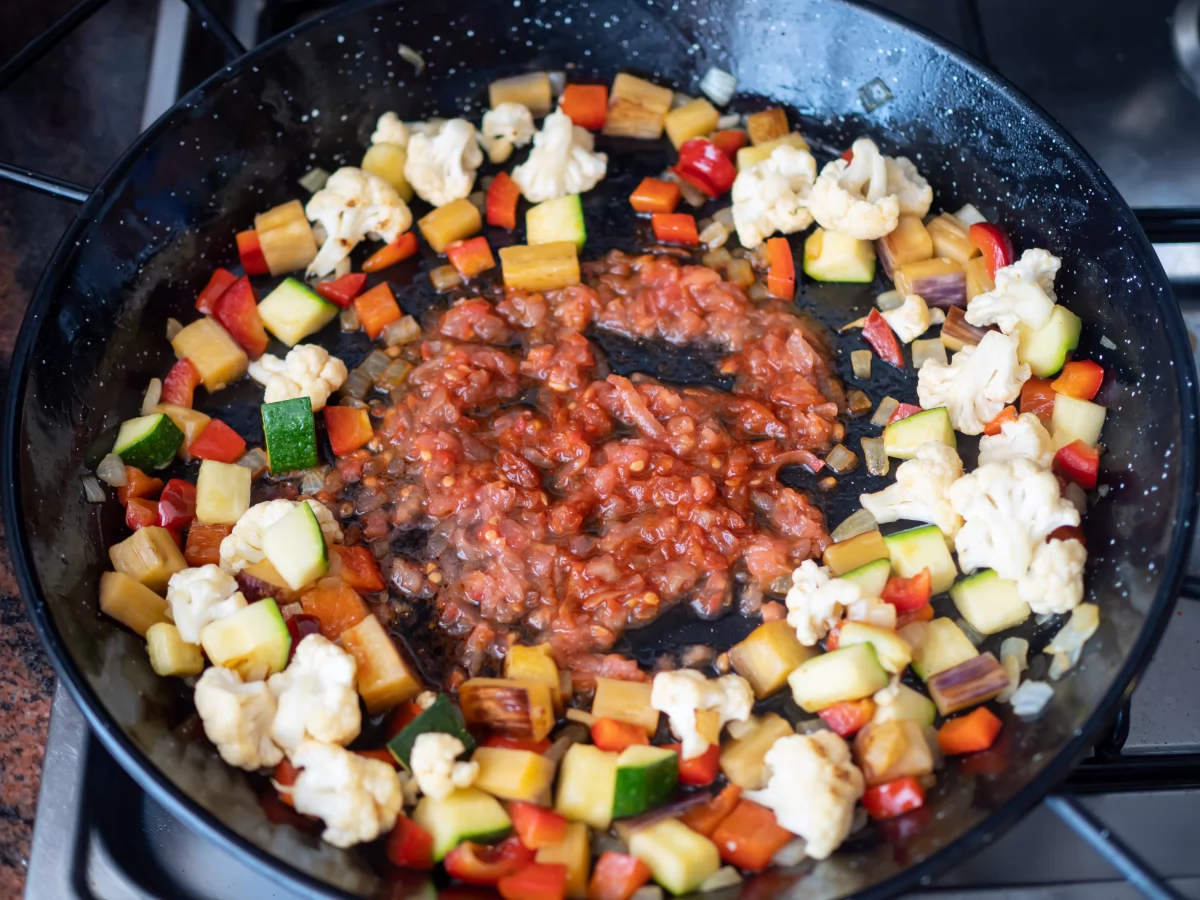 Fideuá de verduras 7 Sofreír el ajo, añadir el pimentón dulce y el tomate rallado para la fideuá de verduras