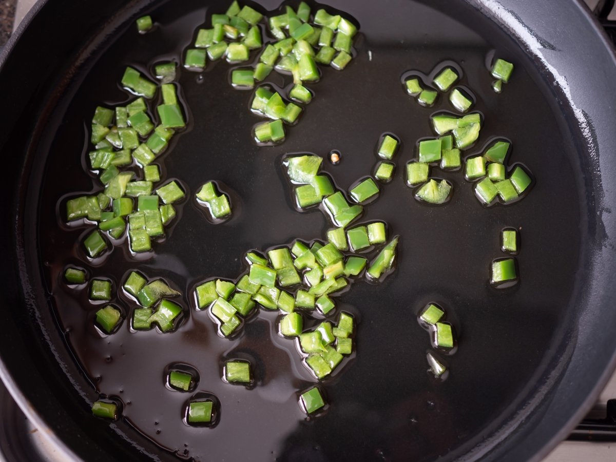 Sofreír el pimiento verde para el arroz con judías verdes