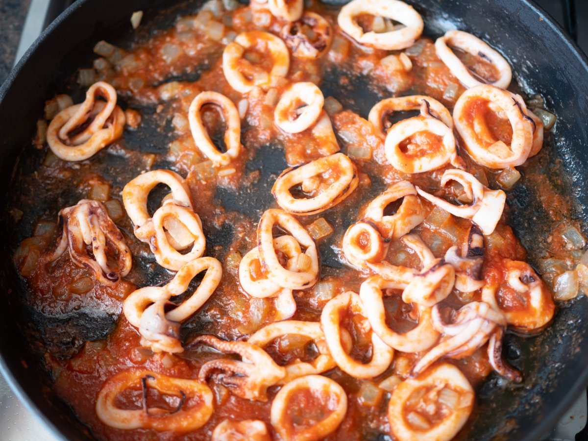 Sofreír el tomate para preparar arroz con pimiento rojo y calamares