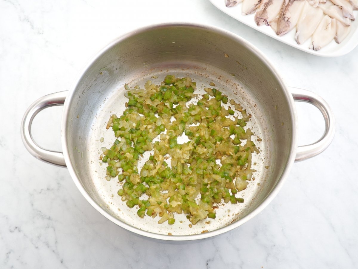 Sofreír la cebolla con el pimiento verde para los chipirones guisados