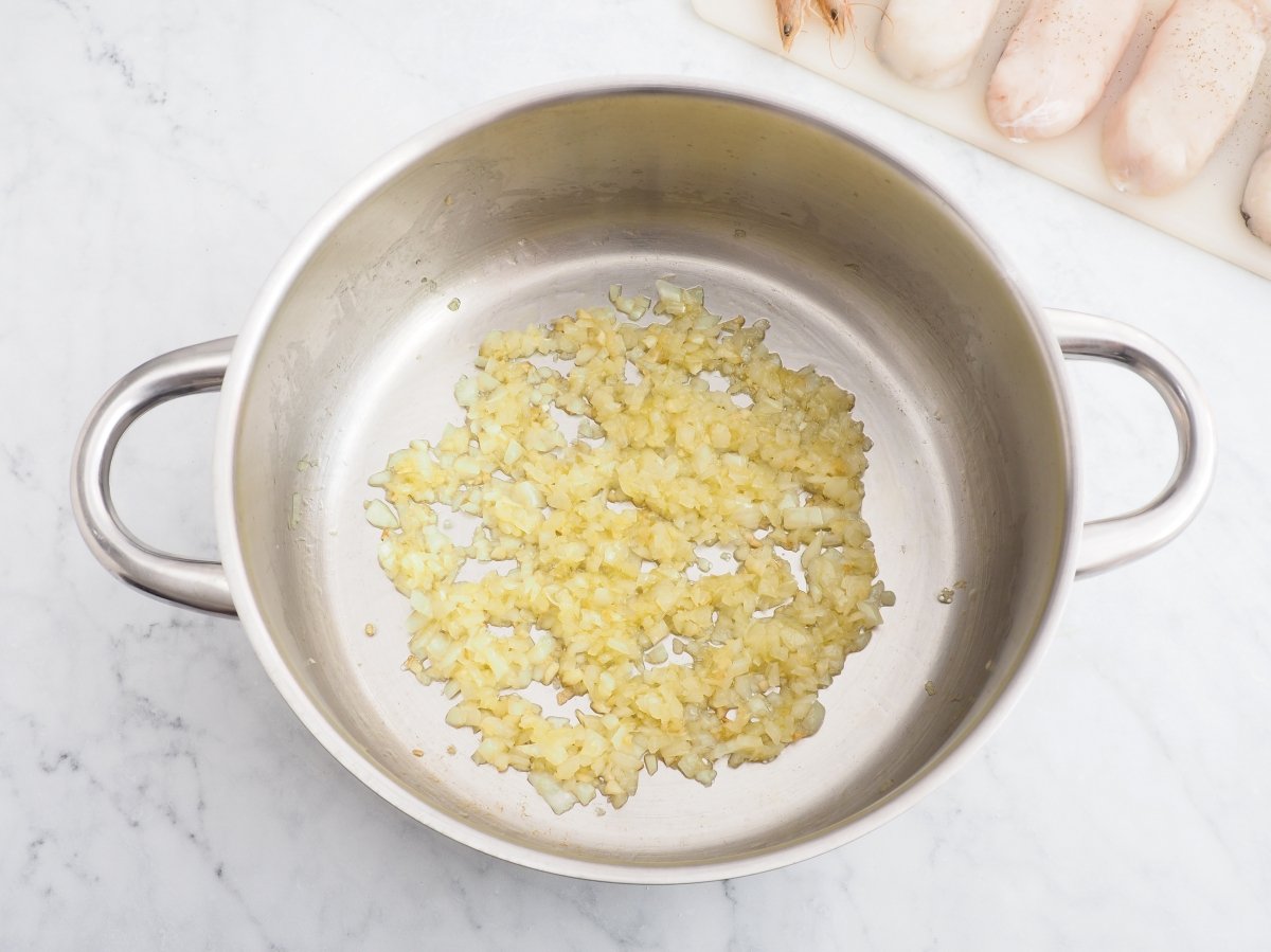 Sofreír la cebolla para la merluza con gambas