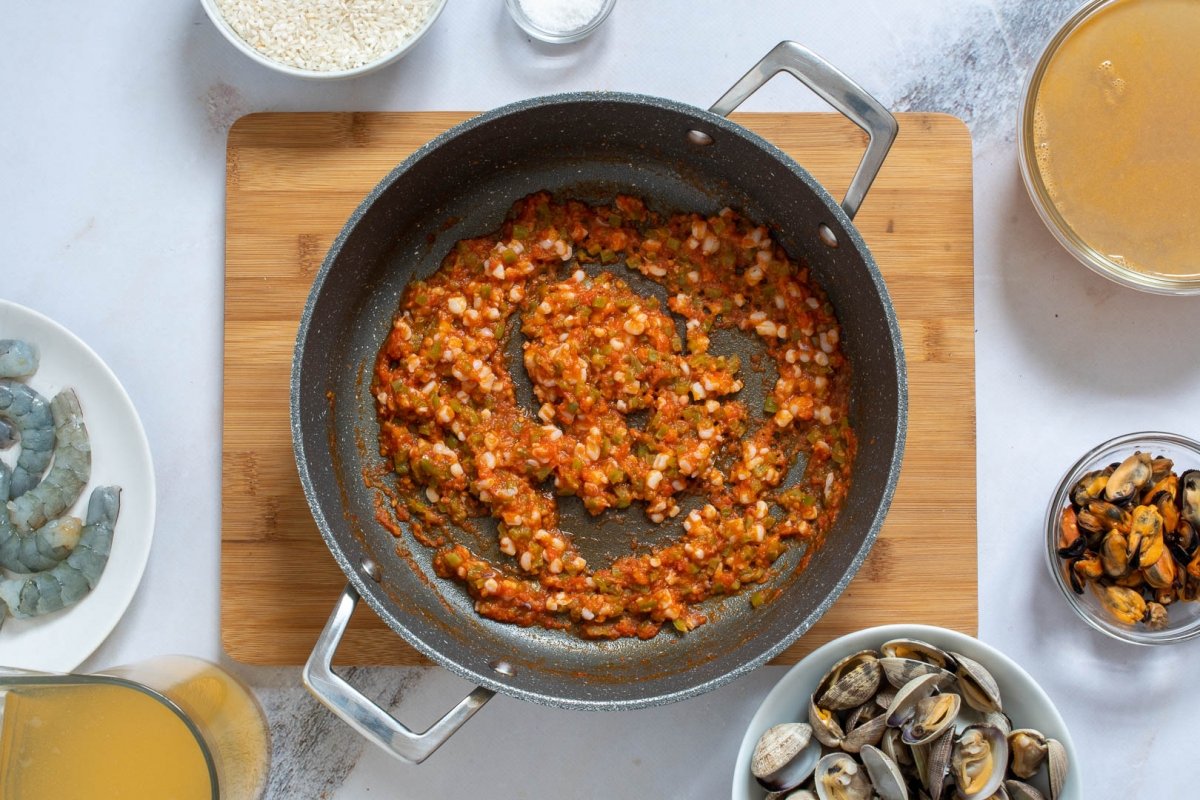 Sofrito de ajo, pimiento, tomate y calamar para arroz caldoso de marisco