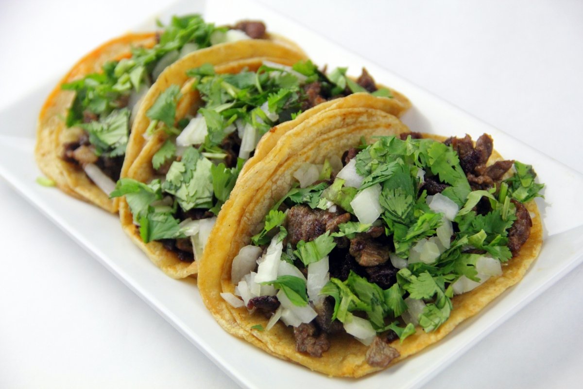 Tacos mexicanos con carne y hojas de cilantro fresco