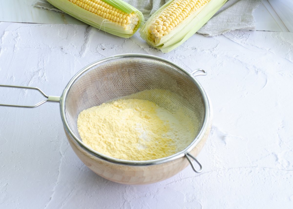Tamizando los ingredientes secos para hacer pan de maíz