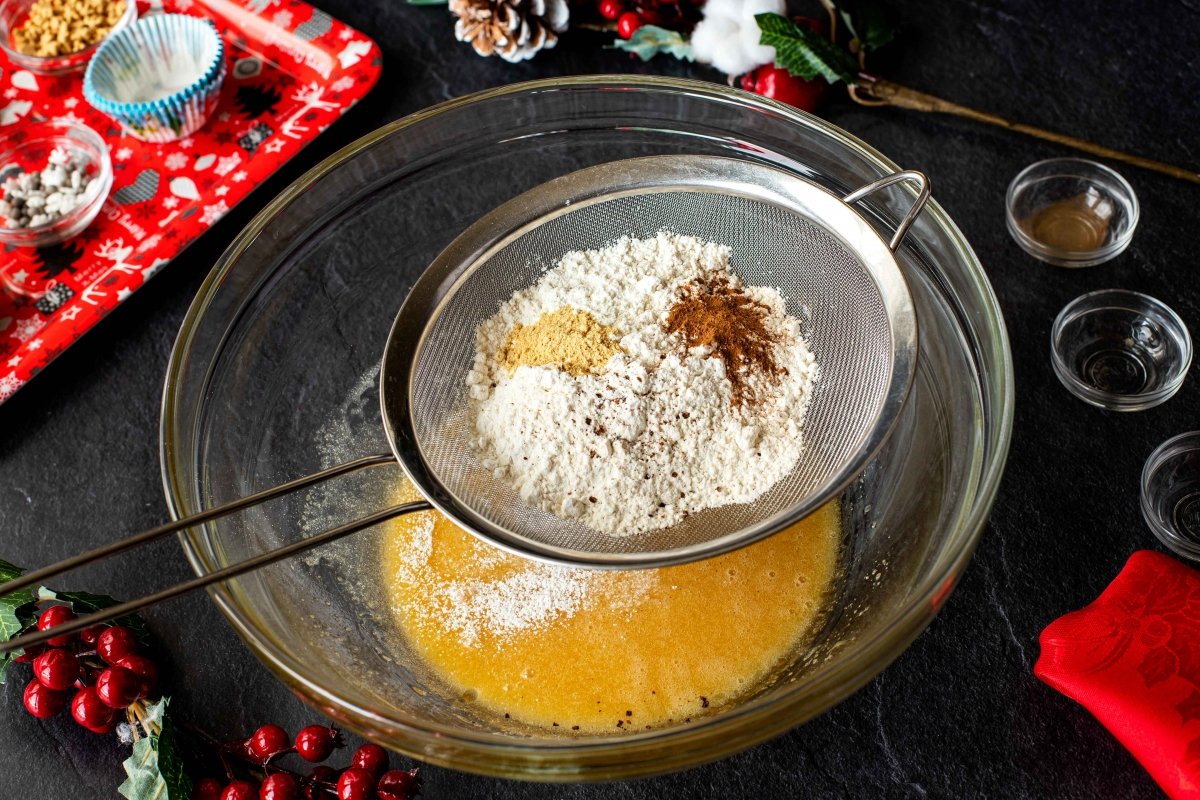 Tamizar harina, especias e impulsor para los cupcakes navideños