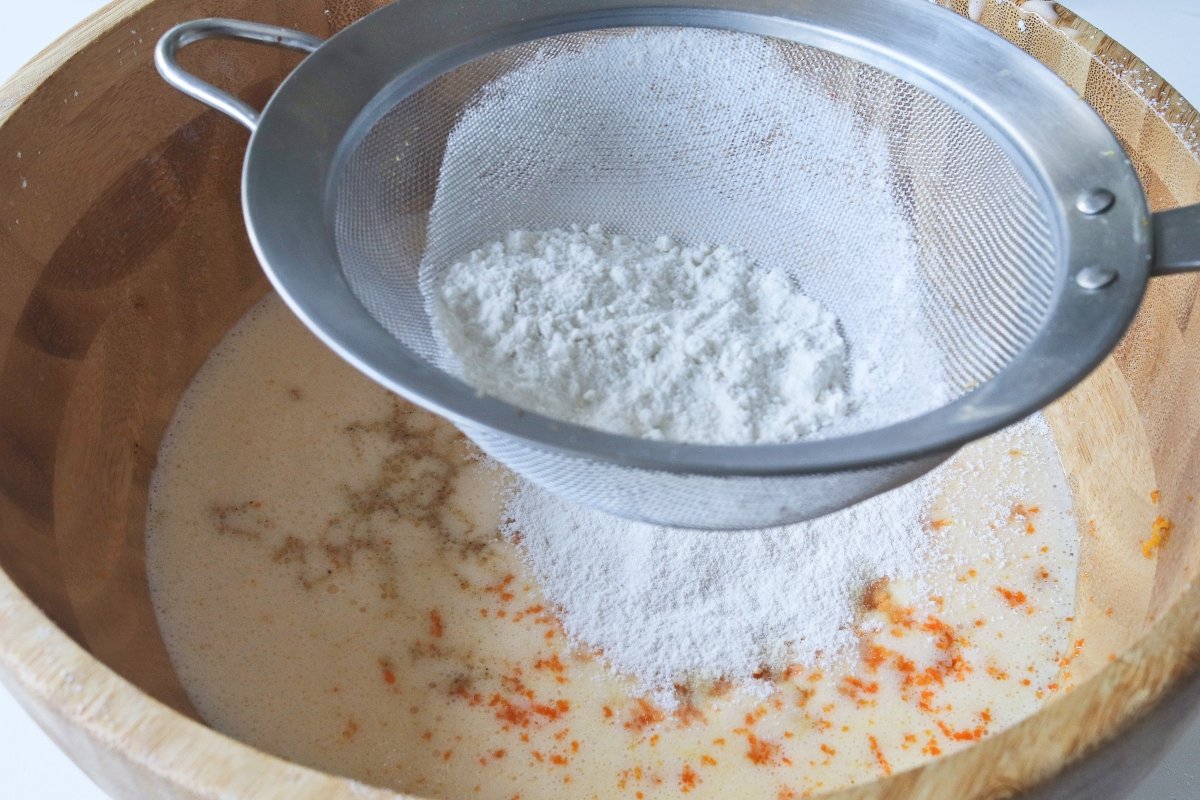 Tamizar la harina leudante para el budín de queso