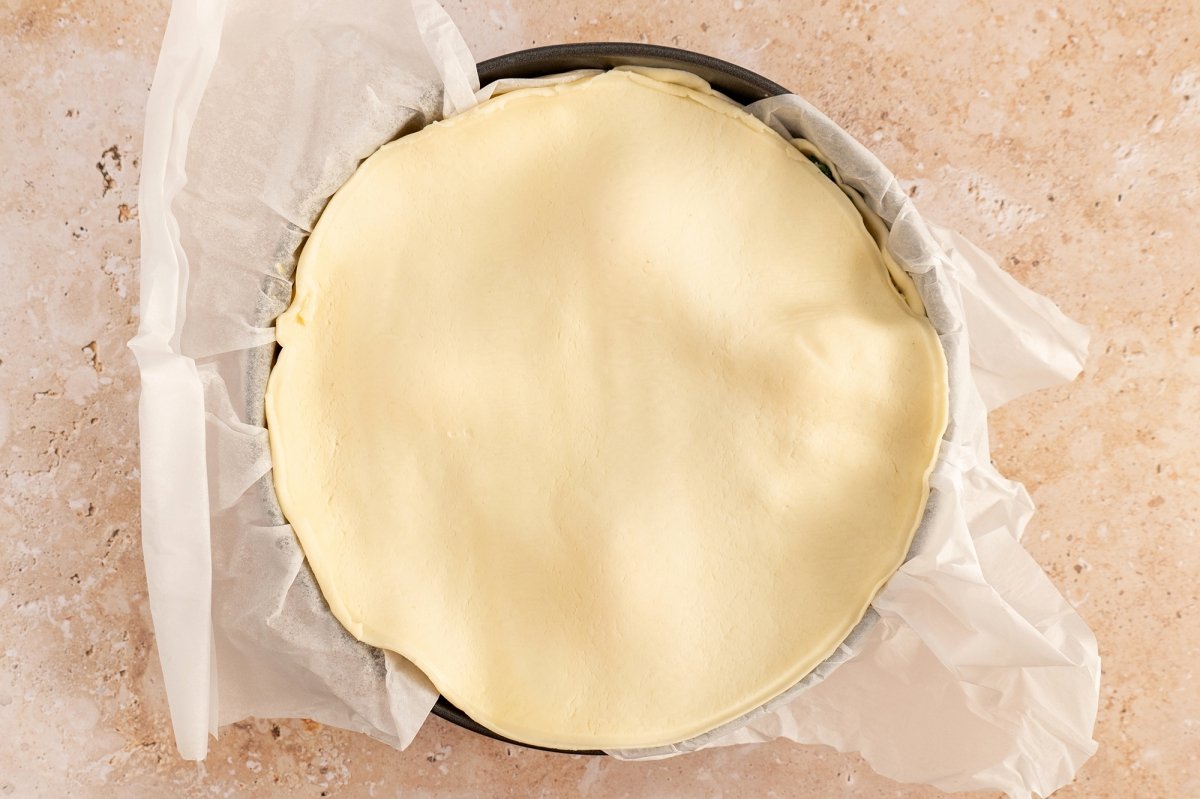 Tapar el molde con la masa brisa para la torta pascualina