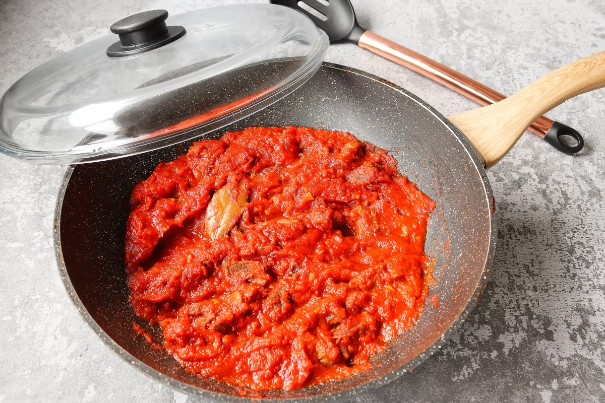 Tapar y guisar la carne de ternera con tomate