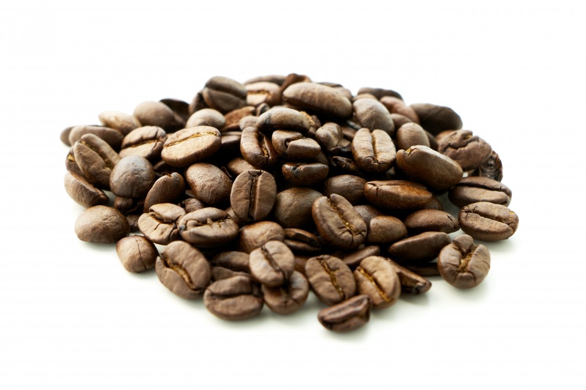 Taza llena de granos de café sobre más granos tostados