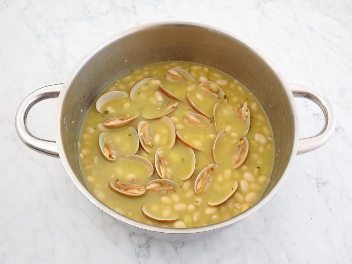 Terminar de cocinar las pochas con almejas