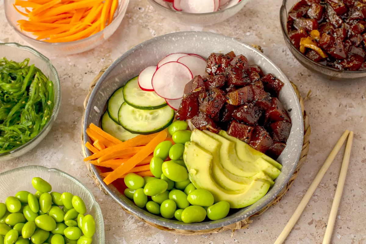 Terminar de montar el poke bowl con el atún marinado y el aguacate *