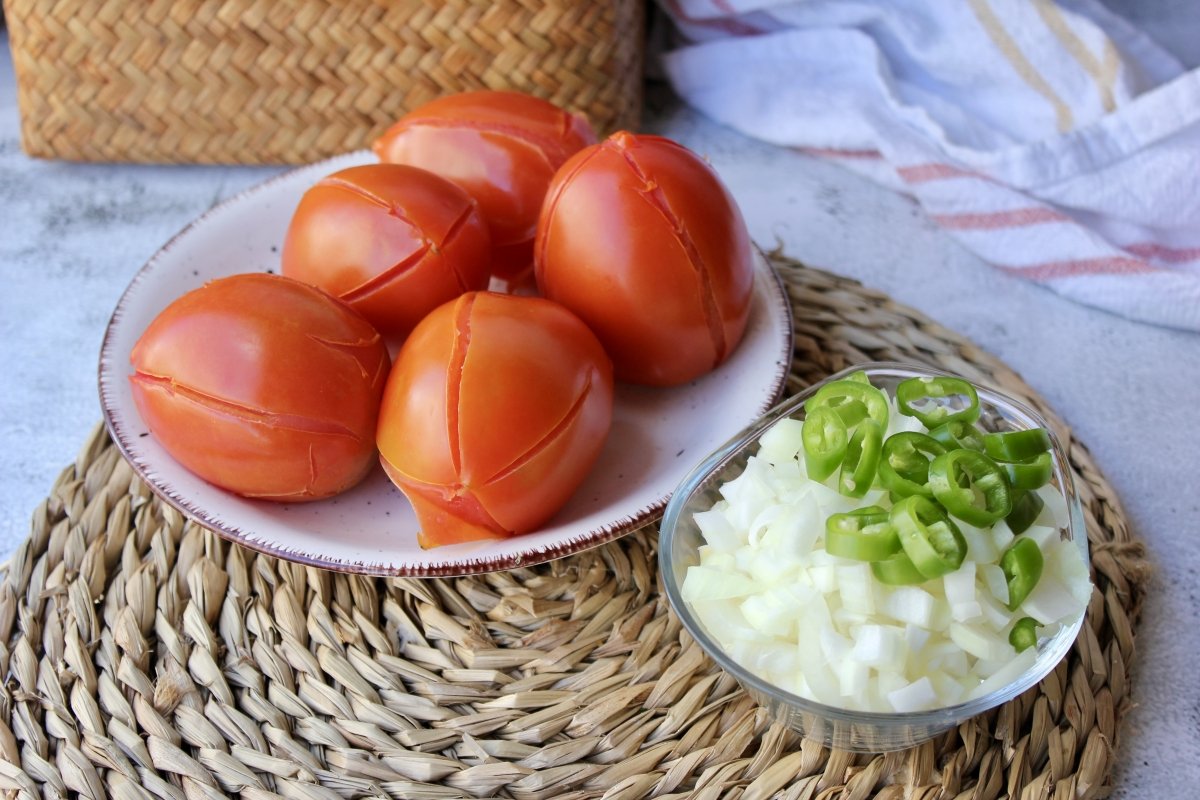 Tomate pera ya escaldados junto con la cebolla y el pimiento serrano troceados para realizar la sals