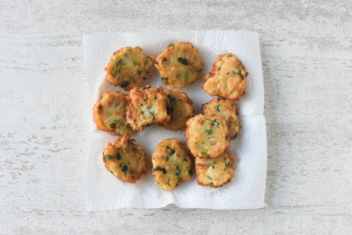 Tortillitas de bacalao escurriendo en un plato con papel absorbente