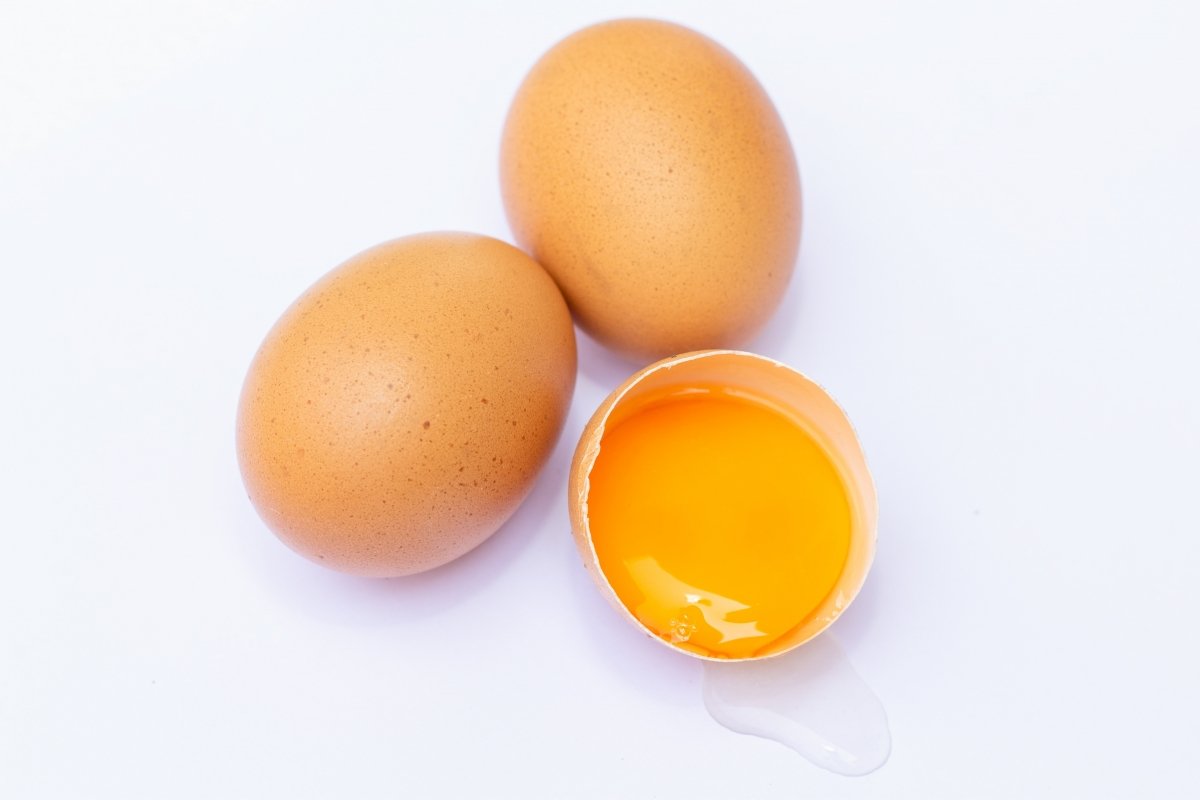 Tres huevos con su cáscara y detalle de la yema