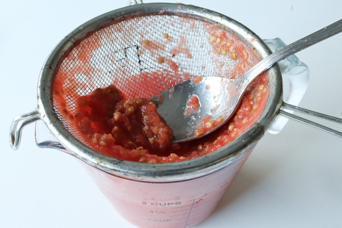 Triturar y pasar el tomate por un colador para hacer el letscho