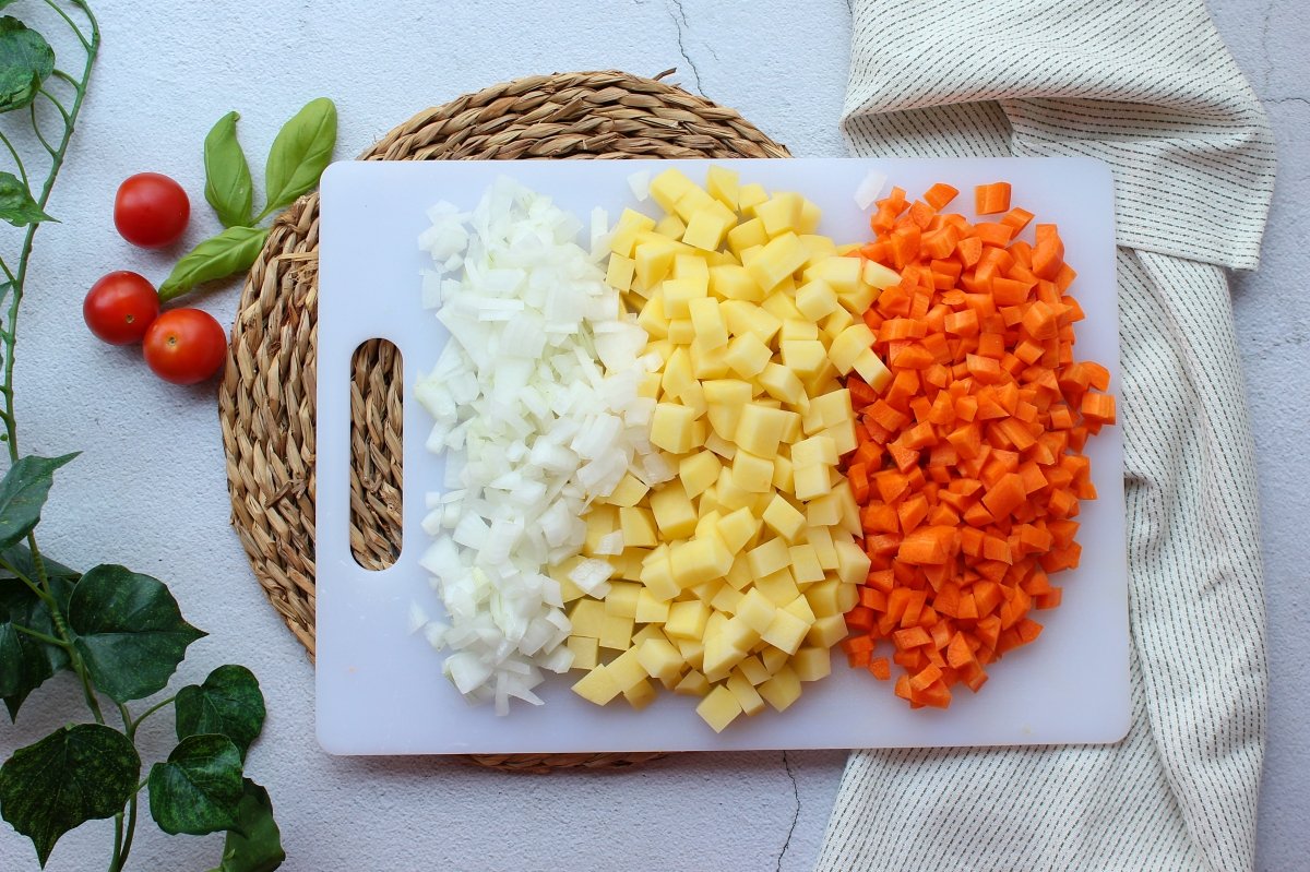 Troceado de la cebolleta, las patatas y las zanahorias