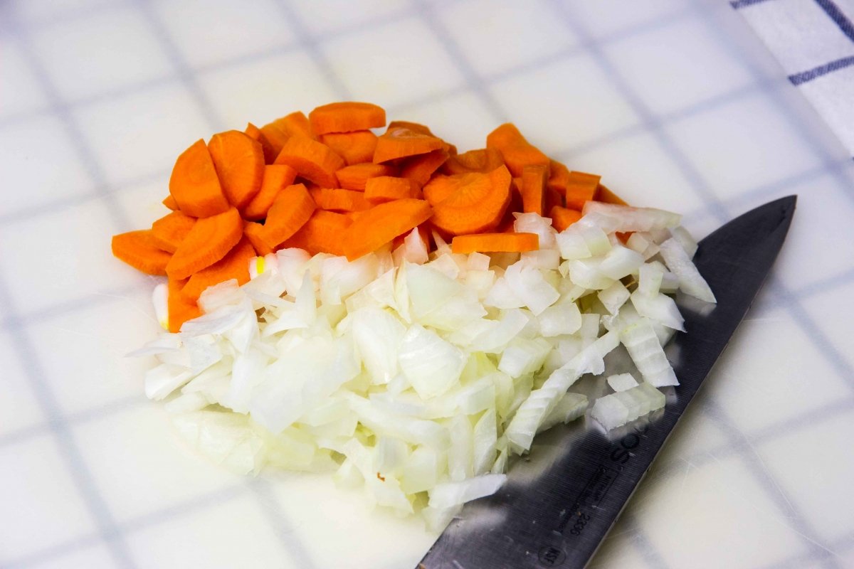 Trocear la cebolla y la zanahoria para hacer las lentejas con espinacas